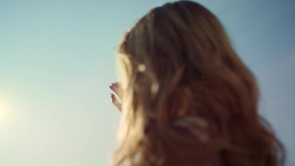 Młoda kobieta z pięknymi włosami stojąca przy słońcu. Pojęcie religijne. — Wideo stockowe