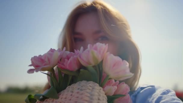 Retrato de mujer hermosa oliendo suave ramo de flores en la reflexión del sol. — Vídeo de stock