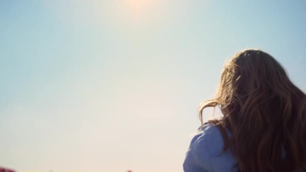 Mooie vrouw met fotocamera genieten van zonnige dag in de blauwe lucht achtergrond. — Stockvideo