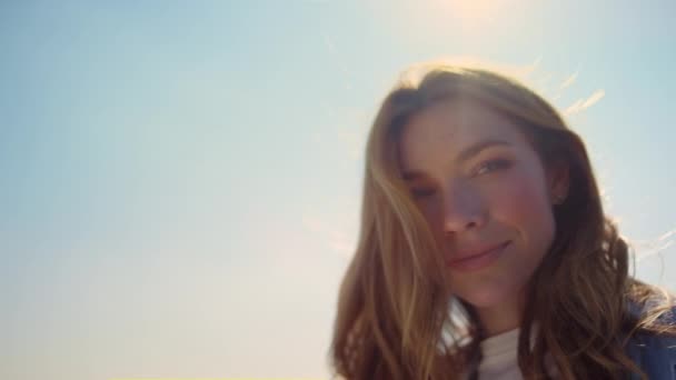 Portrait of beautiful woman in sunlight. Blue-eyed girl face in sunbeams outdoor — Stock Video