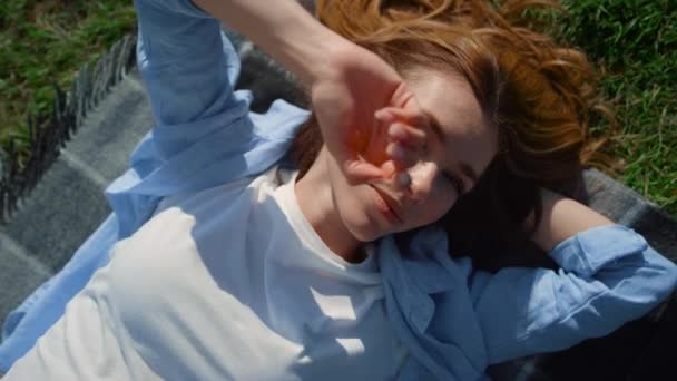 Portret van een speelse vrouw die het gezicht bedekt tegen felle zonnestralen in de voorjaarsweide. — Stockvideo