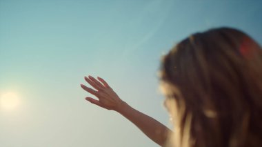 Young woman with camera looking at hand on sunshine background outdoor.