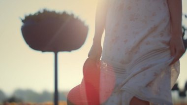 Unknown woman walking in spring park in golden hour. Young lady legs walking.