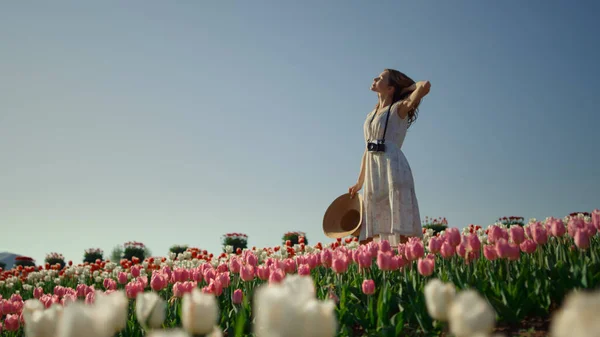 Camera moving around girl staying in tulip field. Woman enjoying summer day. — Foto Stock