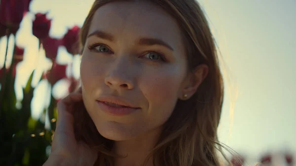 Happy woman touching face in tulip sunlight field. Closeup smiling lady outdoor — Stock Fotó