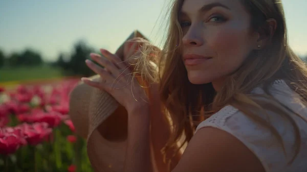 Romantische Frau im Blumengarten. Verträumtes Mädchen sitzt in sonnigem Licht. — Stockfoto