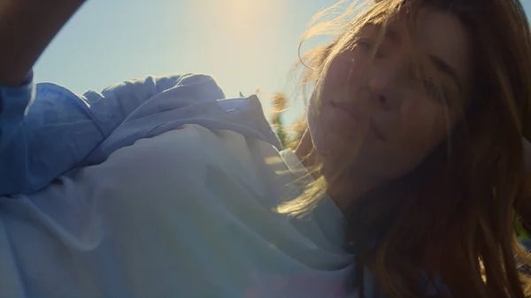 Beautiful woman touching wild blond hair in sunset light in blue sky background. — Φωτογραφία Αρχείου