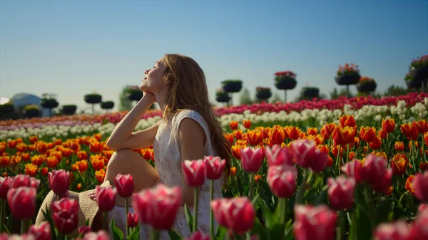 Young woman smiling in bright flower garden. Woman profile in flower background. — Stock Photo, Image