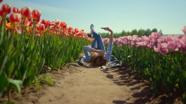 Çiçekli lale güneşli bir günde cep telefonu ekranına bakarak bahar kızında dosyalanmış.