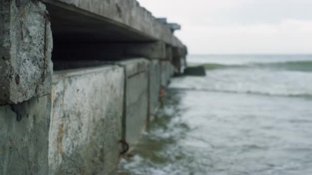 Vagues écrasant pont urbain en bord de mer par temps nuageux. Concept de tristesse. — Video