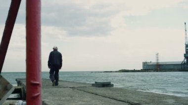 Balık tutan insanlar deniz kıyısındaki köprüde birlikte vakit geçiriyorlar..