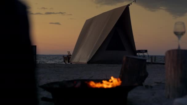 Lidé si užívají kempování při západu slunce v blízkosti táboráku na mořské krajině. Relax koncept. — Stock video
