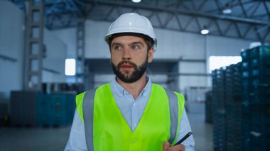 Üniformalı depo işçisi, sevkiyattan önce kutuları teftiş ediyor.