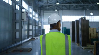 İşçi, nakliye işlemini inceleyen fabrika deposunu kontrol ediyor.