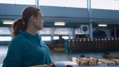 Kadın depo operatörü fabrika teslimat kutuları taşıyan bir sürücü.