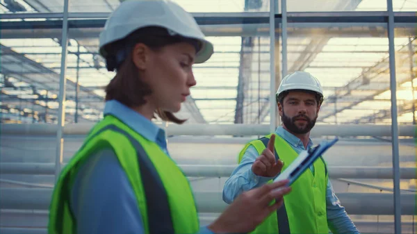 Expertos en ingeniería verifican fábrica vacía perspectiva del producto proceso hablando — Foto de Stock