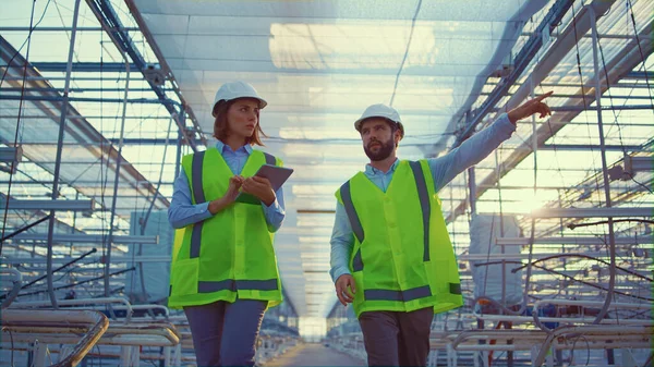 Två lagerarbetare inspekterar produktionsförberedelser i växthussamtal — Stockfoto