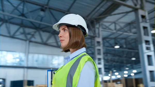 Trabajador de almacén retrato sonriendo casco uniforme reflectante verde enfoque — Foto de Stock