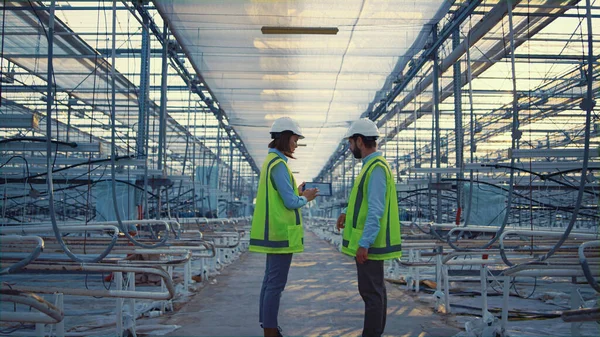 Two factory workers device displaying new safety data engineers discussing