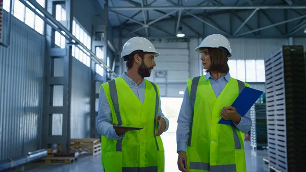 Especialistas en almacenes discuten datos de tabletas inspeccionando complejo de envío — Foto de Stock