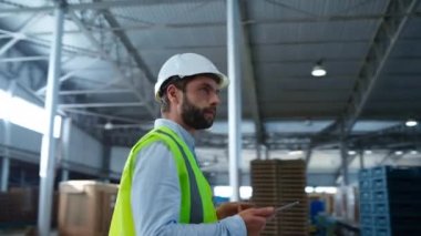 Portre odaklı fabrika çalışanı tablet bilgilerini kontrol ediyor depolama denetliyor