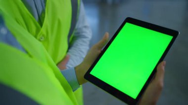 Tablet yeşil ekran taşıyan imalat işçileri üretim verilerini kapatıyorlar