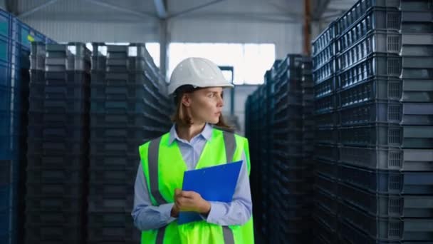 Empleada de almacenamiento femenina inspeccionando cajas de entrega azules administrando envío de fábrica — Vídeo de stock