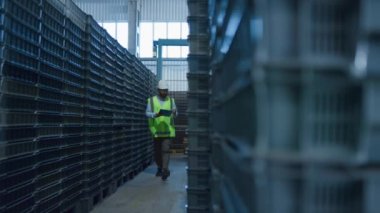 Depo çalışanı kutu numaralarını kontrol ediyor. Depo paketlerini analiz ediyor. 