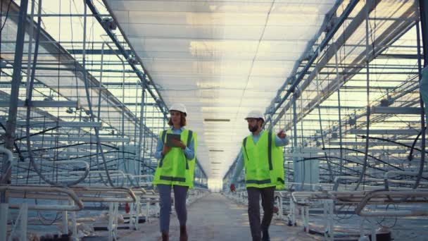 Dos ingenieros planean proceso de producción en invernadero vacío discutiendo — Vídeo de stock