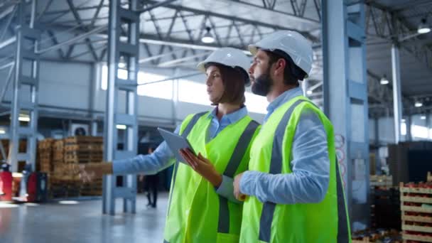 Trabajadores de fábrica discutiendo información de tabletas analizando el proceso de producción — Vídeos de Stock