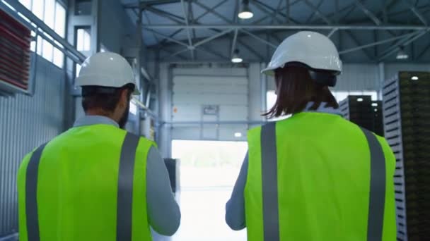 Εργάτες εργοστάσιο πίσω όψη περπάτημα στην αποθήκη συζητώντας τη διαχείριση της αποθήκευσης — Αρχείο Βίντεο
