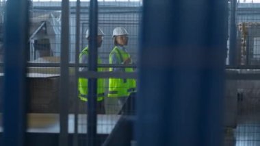 Üretim üretim denetimini tartışan iki üniformalı depo işçisi