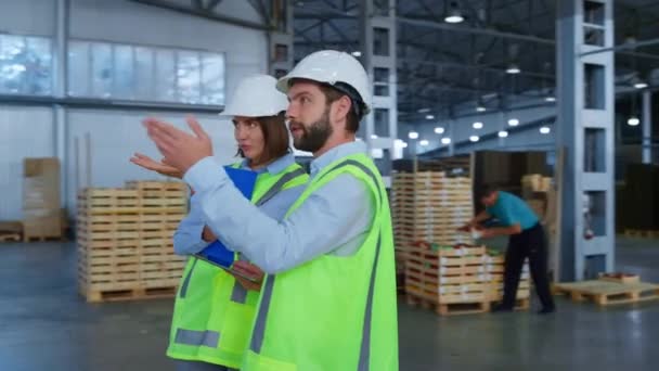 Warehouse specialists checking factory production holding tablet papers talking — Stock Video
