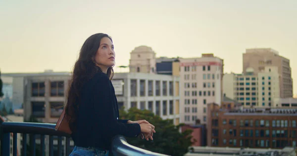 Menina asiática desfrutando de vista para a cidade à noite ao ar livre. Mulher calma ficar perto de grades. — Fotografia de Stock