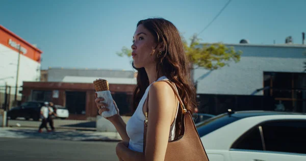 迷人的女孩在街上品尝冰淇淋。亚洲女人舔甜点 — 图库照片