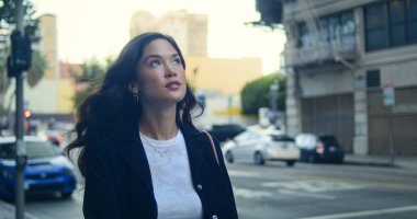 İş kadını, Walk City caddesindeki yakın çekimde eğleniyor. Asyalı kadın kaldırıma çıkıyor.