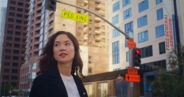 Mutlu kadın yaya geçidine çıkıyor. Yakından. Asyalı iş kadını karşıya geçiyor.