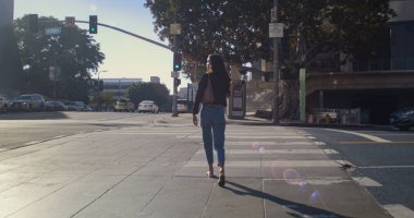 Yaya geçidine çıkan tanınmamış esmer. Bilinmeyen kız turist caddeyi geçiyor..