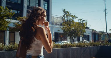 Dondurma yiyen Asyalı kadın. Bir kadın sokakta tatlı yalıyor..