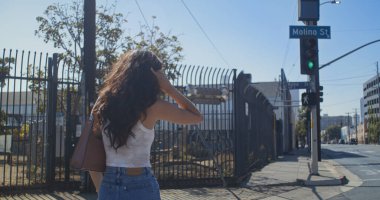 Karşıdan karşıya geçen tanınmayan bir kadın. Arkaya bakan genç kız yaya geçidine çıkıyor..