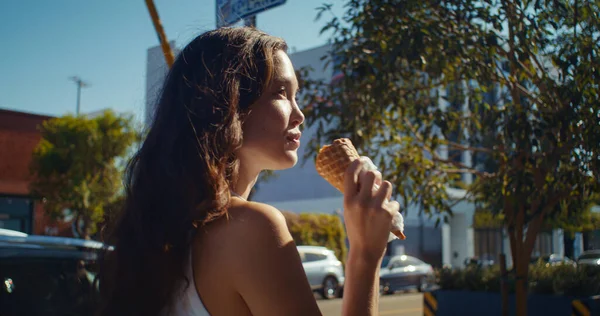 สาวที่มีความสุขเลียไอศกรีมในการเดิน ผู้หญิงเอเชียถืออาหารหวาน closeup . — ภาพถ่ายสต็อก