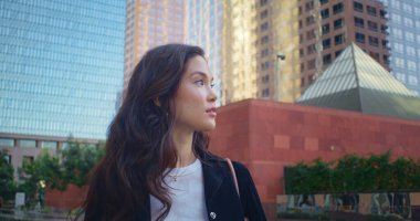 Kasabada yürüyen güzel bir kadın. Asyalı kız şehir mimarisinden hoşlanıyor.