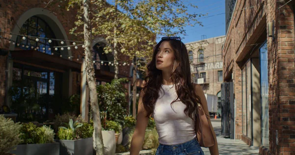 Menina lindo explorando rua da cidade. Morena passeio turístico no distrito verde. — Fotografia de Stock