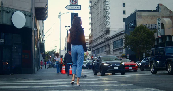 Büyük şehir kavşağında yürüyen tanınmayan bir kadın. Bilinmeyen kız karşıya geçiyor.. — Stok fotoğraf