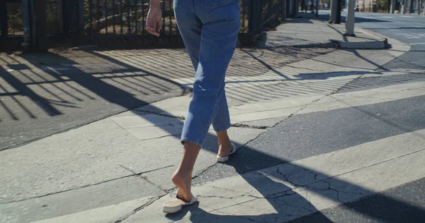 知られていない女性の足を横断歩道を歩く。認識できない少女が道路を横断. — ストック写真