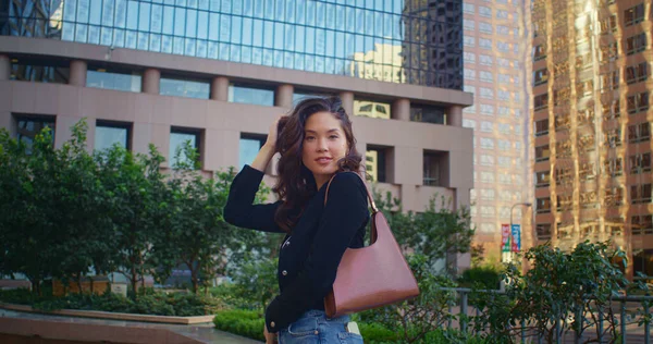 Menina asiática posando no arranha-céu da frente. Mulher elegante sorrindo na câmera na rua — Fotografia de Stock