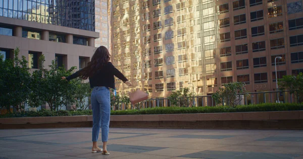 Den sorglösa kvinnan snurrar på stadens gata. Glada asiatiska flicka promenader megapolis. — Stockfoto