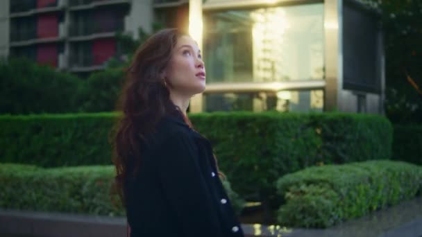 Confident asian businesswoman walking alone watching city architecture side view — Stock Video