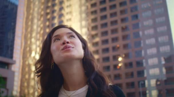 건물 위를 올려다보는 여성의 모습. 가까이 서 도시를 탐험하는 아시아 여성. — 비디오