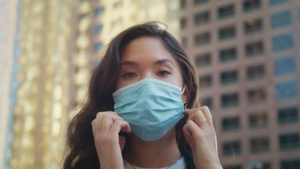 Asijská brunetka sundat masku zblízka. Zdravý život ve velkém městě koncept. — Stock video